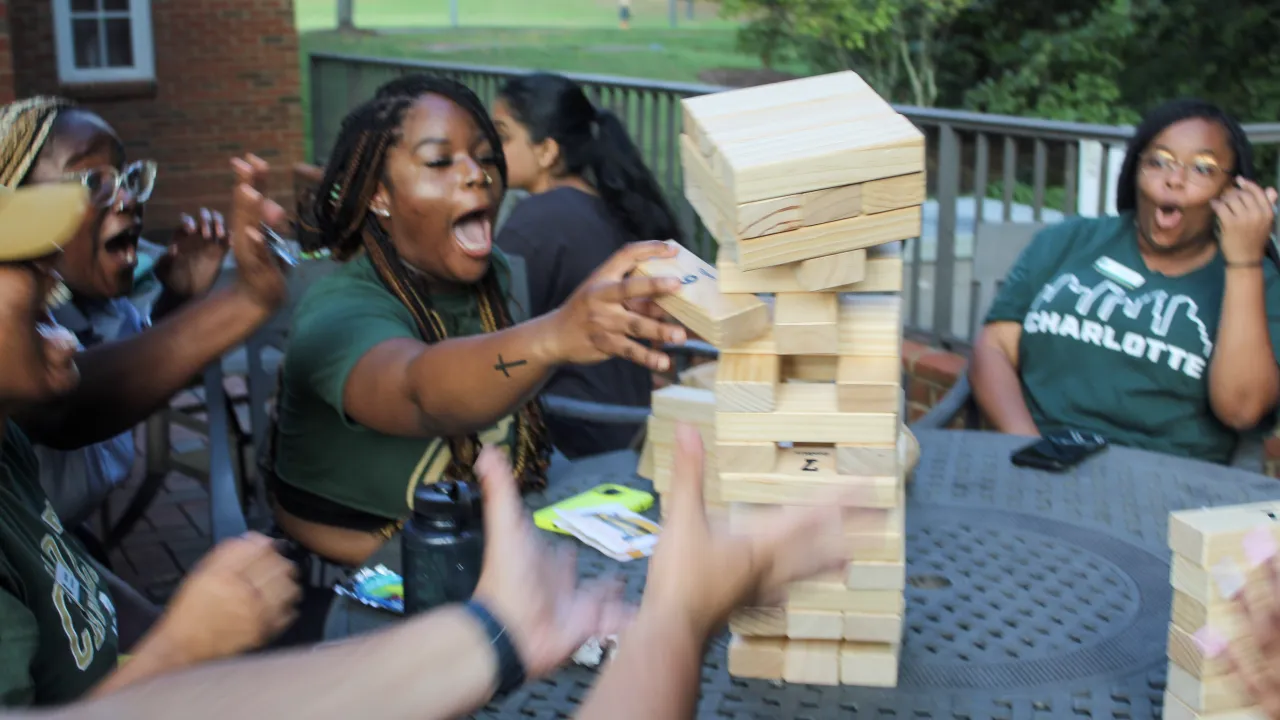 Students at Alumni Bash playing Giant Jenga (Blocks are falling)
