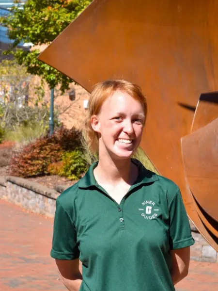 person with red hair smiling wearing a green t-shirt