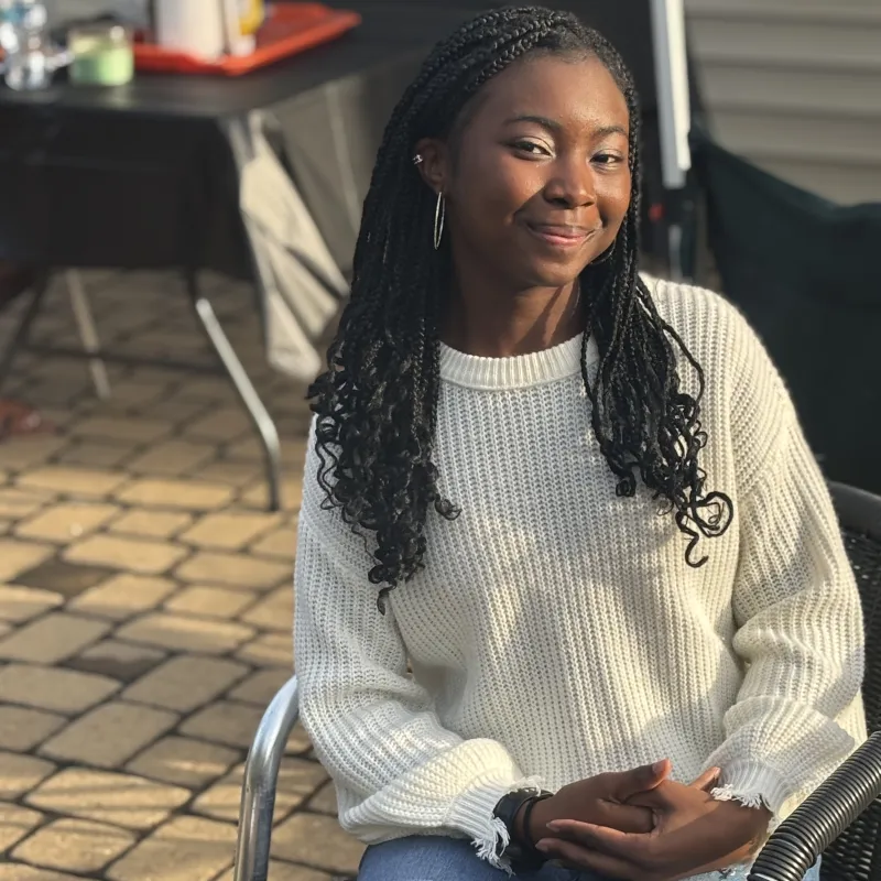 Image of scholarship recipient sitting in a chair outside.