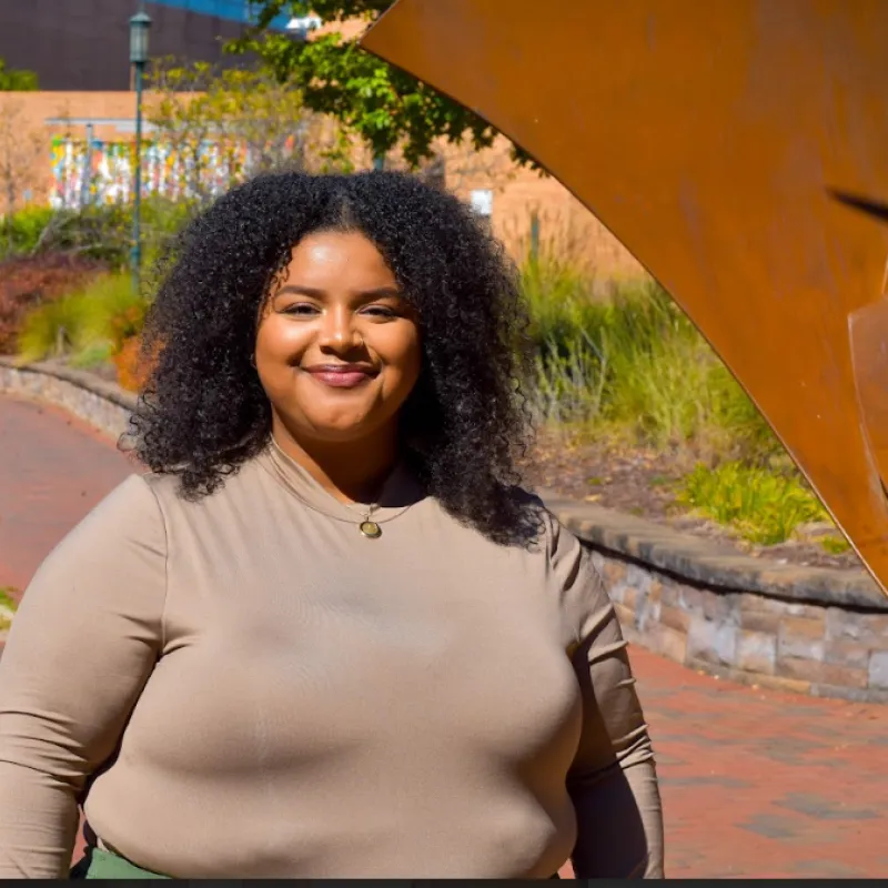 Person wearing brown shirt smiling 