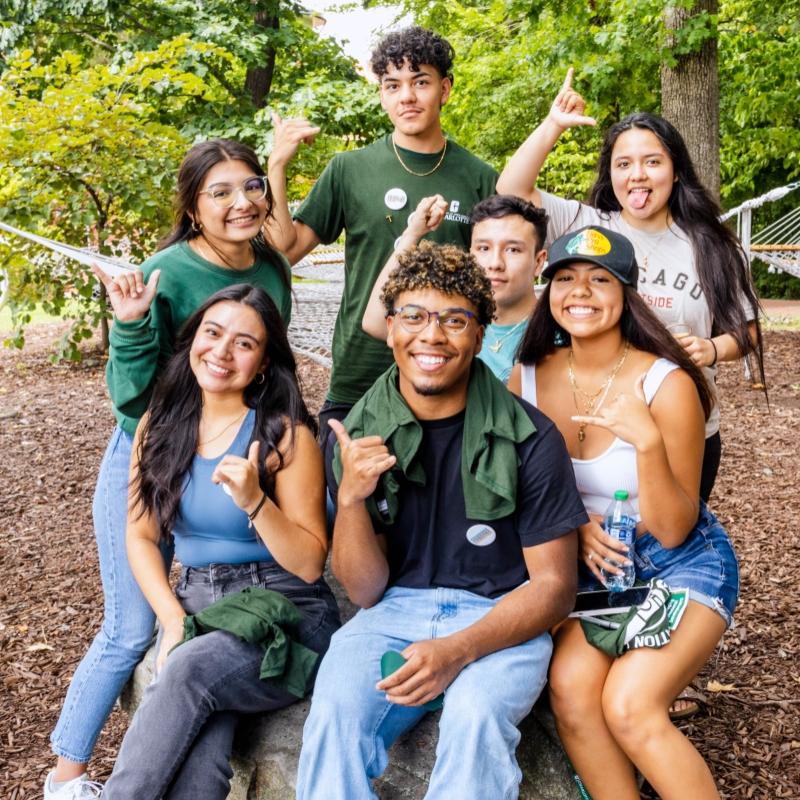 Excited group of students sitting on a rock